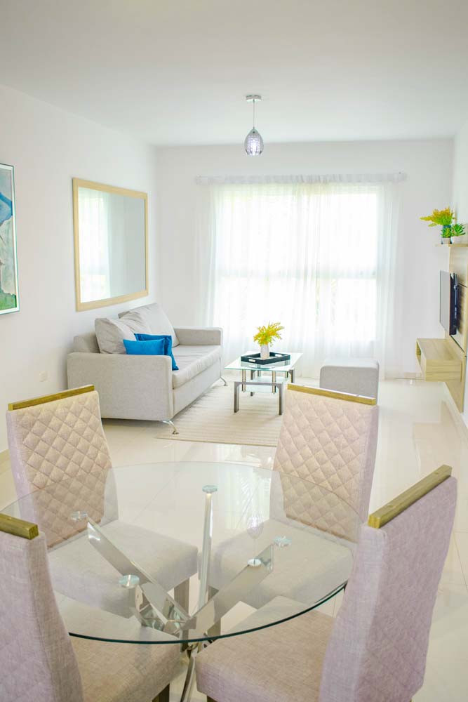 Glass dining table and bay window to the living room at Beach Apartamentos in Playa Palmera